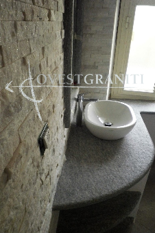 Ambientazione bagno in pietra di luserna blu spazzolata, rivestimento muro in marmo cristallino bianco.