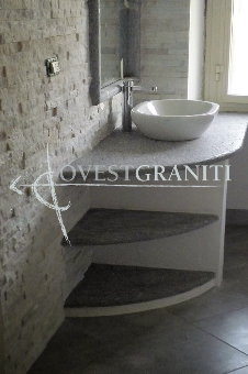 Ambientazione bagno in pietra di luserna blu spazzolata, rivestimento muro in marmo cristallino bianco.