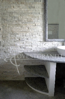 Ambientazione bagno in pietra di luserna blu spazzolata, rivestimento muro in marmo cristallino bianco.